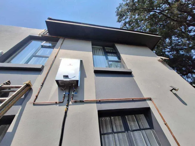 Solar water heating unit installed on an exterior wall
